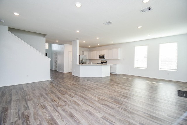 7303 Dover View Ln, Katy, TX 77493 - unfurnished living room featuring recessed lighting, healthy amount of natural light, light wood-style flooring, and baseboards