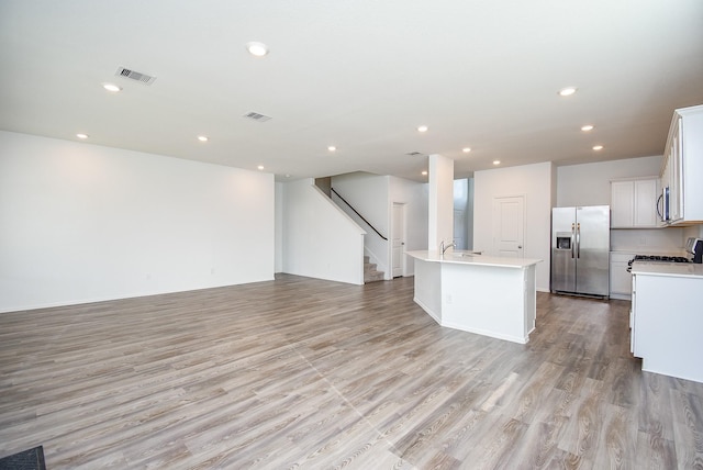 7303 Dover View Ln, Katy, TX 77493 - kitchen featuring stainless steel appliances, open floor plan, light wood finished floors, light countertops, and recessed lighting