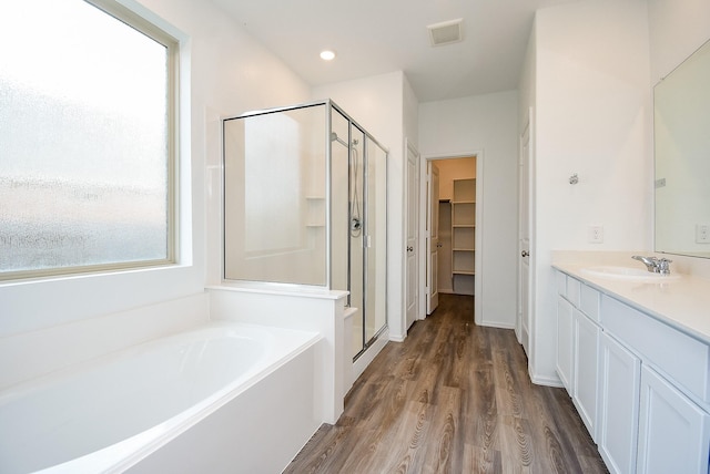 7303 Dover View Ln, Katy, TX 77493 - full bathroom with a stall shower, wood finished floors, a garden tub, a walk in closet, and vanity