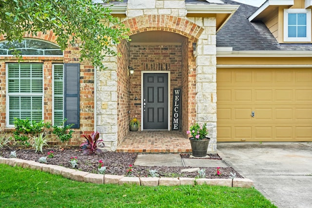 property entrance with an attached garage, brick siding, a shingled roof, driveway, and stone siding