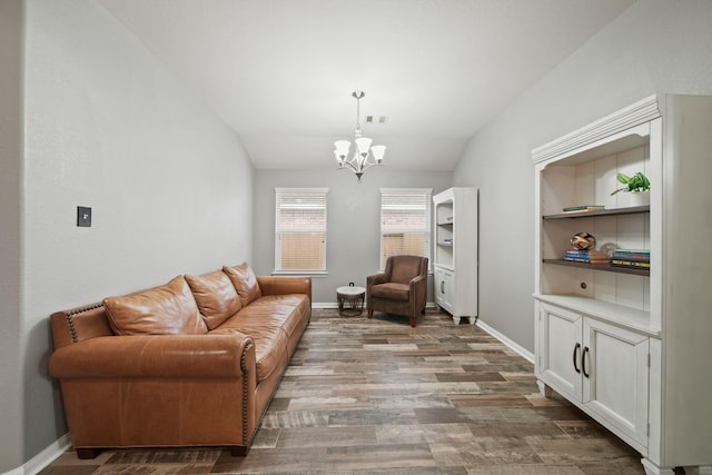 living room with lofted ceiling, a chandelier, wood finished floors, and baseboards