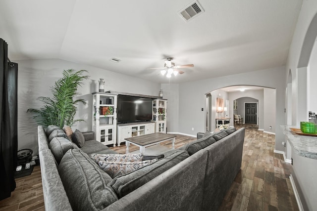 living area with arched walkways, a ceiling fan, wood finished floors, baseboards, and lofted ceiling