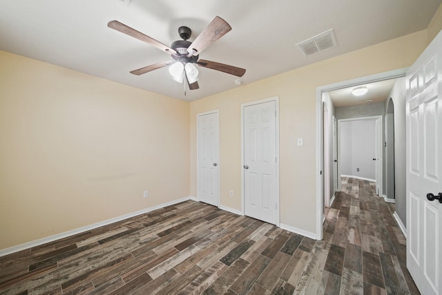 unfurnished bedroom featuring dark wood finished floors, baseboards, and a ceiling fan