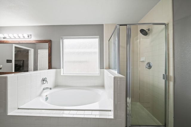 bathroom with a stall shower and a bath