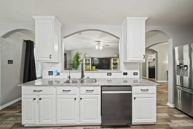 kitchen with stainless steel appliances, a sink, ceiling fan, and backsplash
