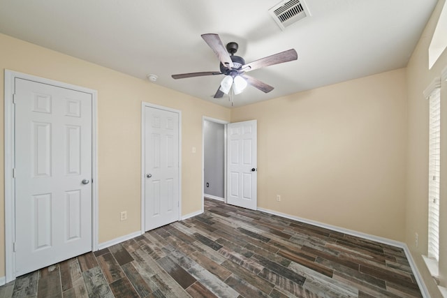 unfurnished bedroom featuring baseboards, dark wood-type flooring, and ceiling fan