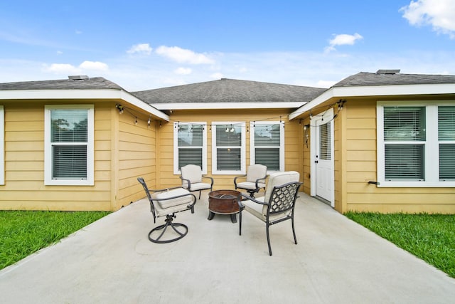 back of house with an outdoor fire pit and a patio