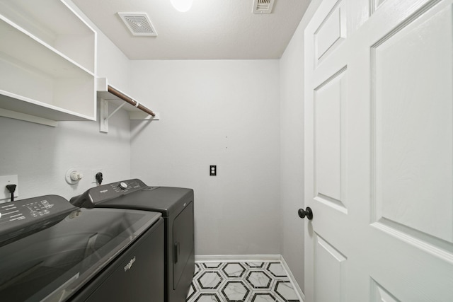 clothes washing area with independent washer and dryer and baseboards