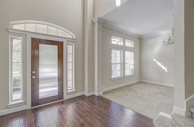 entrance foyer featuring crown molding, hardwood / wood-style floors, baseboards, and a high ceiling