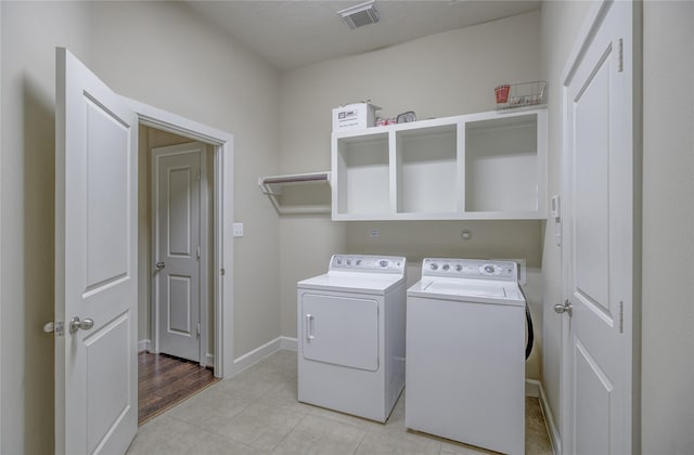 laundry room with washer and clothes dryer, light tile patterned floors, and baseboards