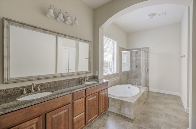 full bath featuring a bath, a shower stall, and double vanity