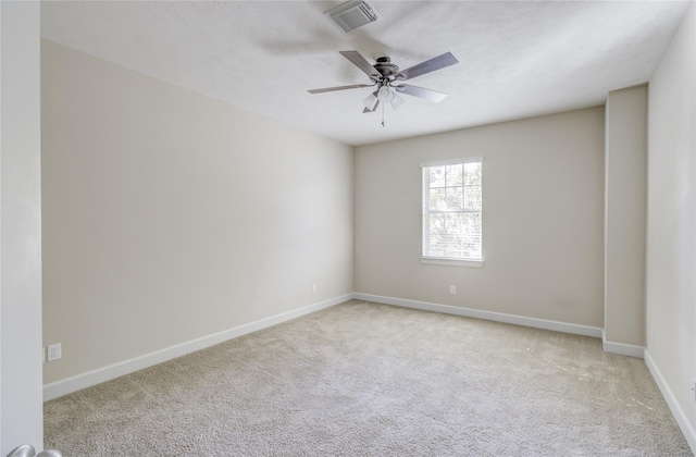 carpeted empty room featuring ceiling fan and baseboards