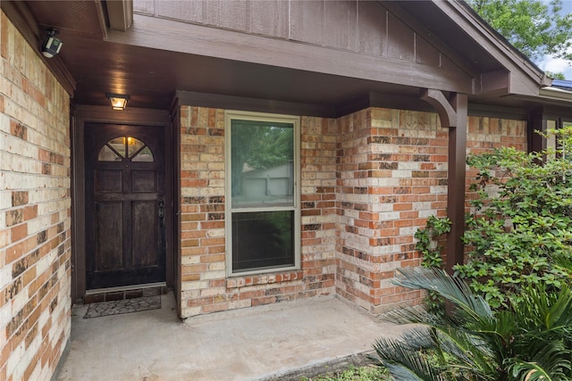view of exterior entry with brick siding