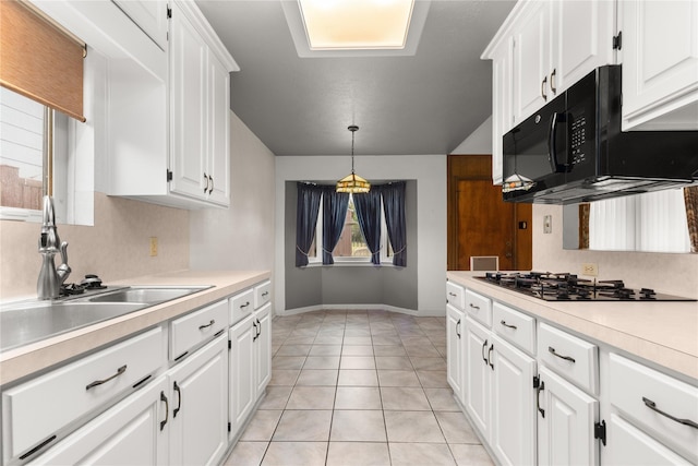 kitchen with black appliances, light countertops, white cabinetry, baseboards, and hanging light fixtures