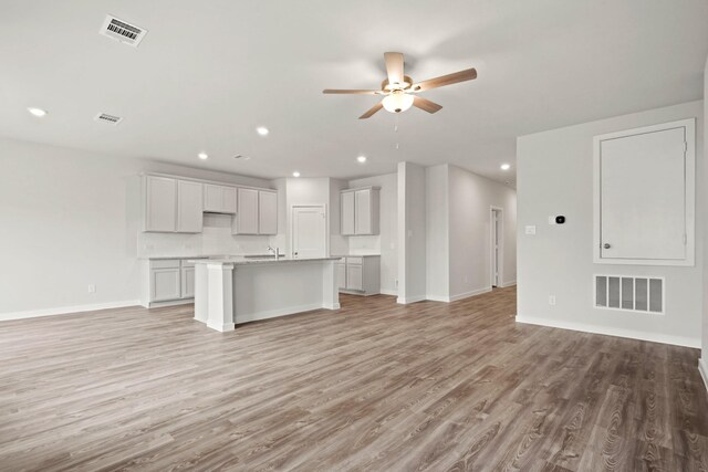 11664 Wilgers Way, Willis, TX 77378 - unfurnished living room with a ceiling fan, light wood finished floors, baseboards, a sink, and recessed lighting