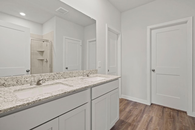 11664 Wilgers Way, Willis, TX 77378 - full bathroom featuring a shower stall, wood finished floors, double vanity, and baseboards