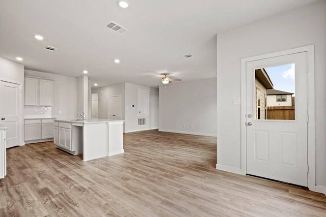 11664 Wilgers Way, Willis, TX 77378 - kitchen with recessed lighting, a kitchen island with sink, light wood-style floors, ceiling fan, and baseboards