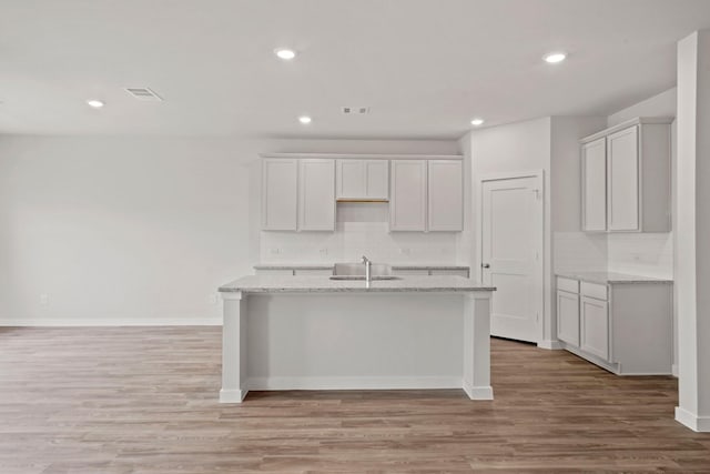 11664 Wilgers Way, Willis, TX 77378 - kitchen featuring a sink, a center island with sink, decorative backsplash, light wood-type flooring, and recessed lighting