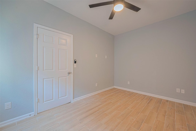 empty room featuring ceiling fan, light wood-style flooring, and baseboards