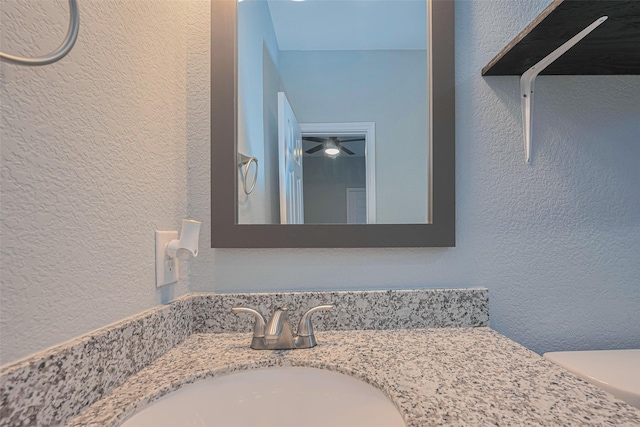 bathroom with a textured wall and vanity
