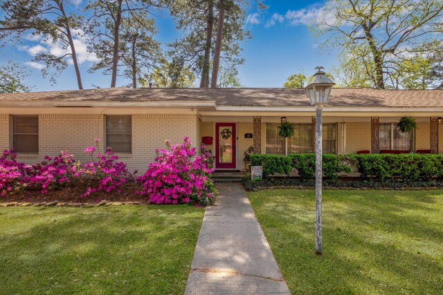 111 Circle Dr, Cleveland, TX 77327 - ranch-style house featuring brick siding, a front lawn, and a porch