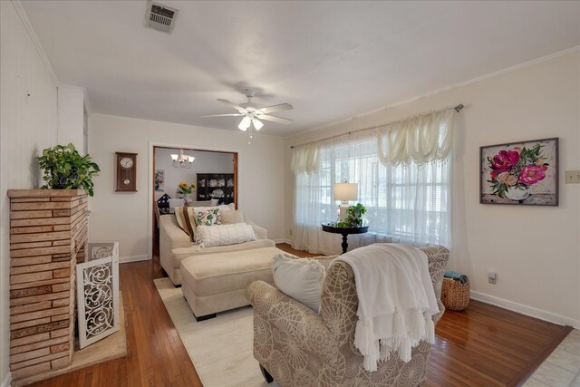 111 Circle Dr, Cleveland, TX 77327 - living room featuring wood finished floors, ceiling fan, ornamental molding, and a chandelier