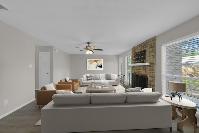 living room featuring wood finished floors, a ceiling fan, a fireplace, and baseboards