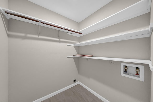 clothes washing area featuring washer hookup, hookup for an electric dryer, baseboards, and wood finished floors