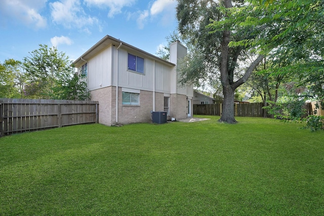 rear view of property featuring a chimney, central air condition unit, and brick siding