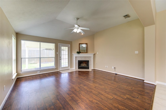 1826 Oak Lodge Dr, Pearland, TX 77581 - unfurnished living room with a ceiling fan, wood-type flooring, vaulted ceiling, a tile fireplace, and baseboards