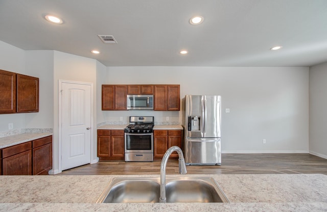 3514 Vivaldi Dr, Katy, TX 77493 - kitchen with appliances with stainless steel finishes, a sink, wood finished floors, light countertops, and recessed lighting