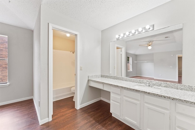 12215 Oldenburg Ln, Houston, TX 77065 - full bath featuring wood finished floors, ceiling fan, vanity, a textured ceiling, and toilet