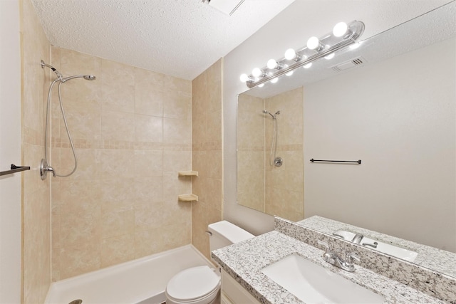 12215 Oldenburg Ln, Houston, TX 77065 - bathroom with tiled shower, toilet, a textured ceiling, and vanity