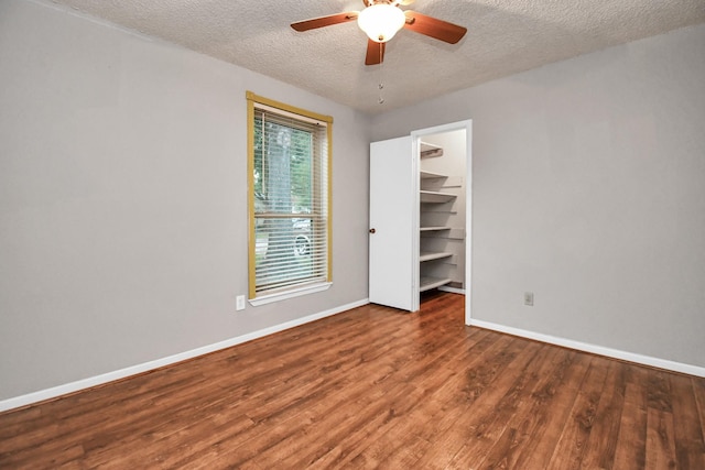 15011 Cypress Ridge Dr, Cypress, TX 77429 - unfurnished bedroom featuring wood finished floors, baseboards, a textured ceiling, a spacious closet, and a ceiling fan
