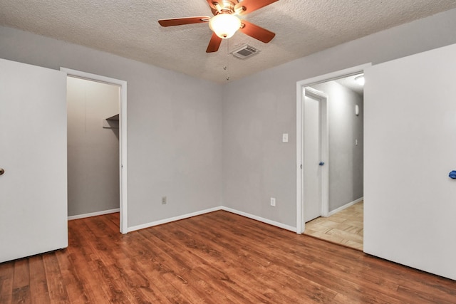 15011 Cypress Ridge Dr, Cypress, TX 77429 - empty room with wood finished floors, a ceiling fan, a textured ceiling, and baseboards