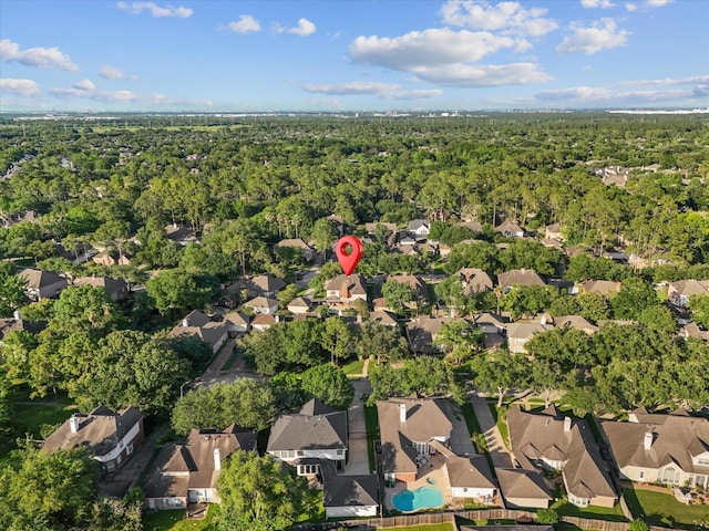 aerial view of property and surrounding area featuring nearby suburban area and a forest
