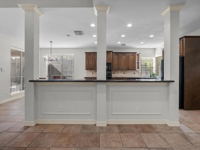 kitchen featuring decorative columns, dark countertops, recessed lighting, and a chandelier
