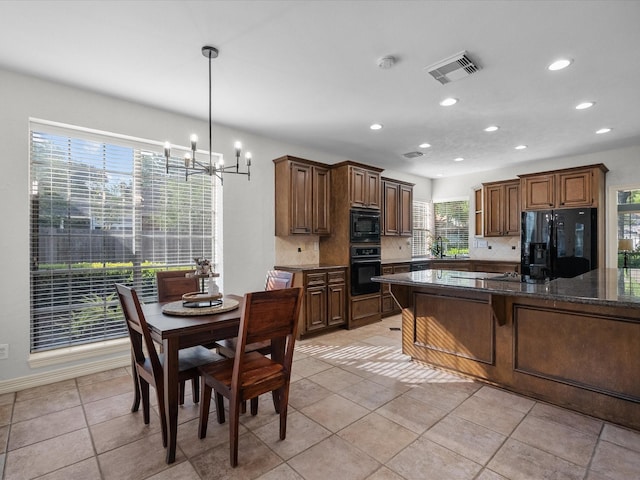 kitchen featuring black appliances, a chandelier, recessed lighting, decorative backsplash, and a breakfast bar