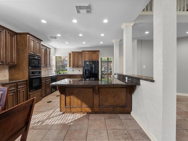 kitchen featuring black appliances, recessed lighting, backsplash, a sink, and dark stone counters