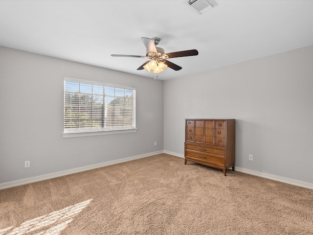 unfurnished room featuring light carpet, a ceiling fan, and baseboards