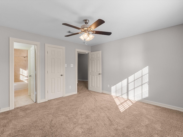 unfurnished bedroom with carpet, baseboards, ensuite bathroom, and ceiling fan
