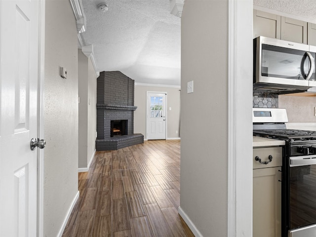 1726 Meadow Green Dr, Missouri City, TX 77489 - hall featuring a textured ceiling, baseboards, dark wood-style flooring, lofted ceiling, and ornamental molding