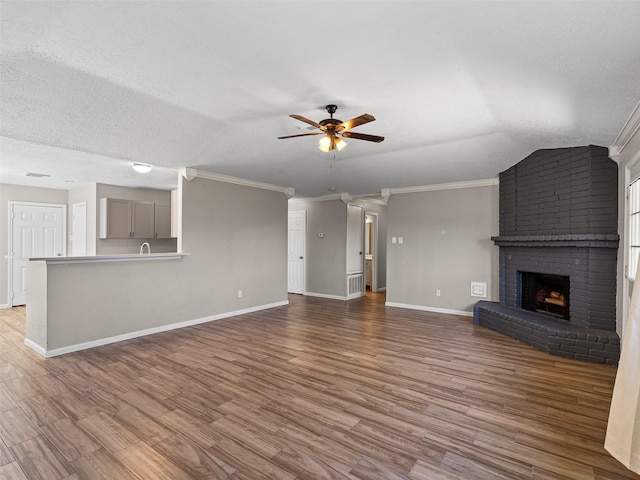 1726 Meadow Green Dr, Missouri City, TX 77489 - unfurnished living room with ceiling fan, baseboards, wood finished floors, a fireplace, and crown molding