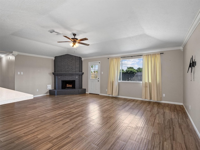 1726 Meadow Green Dr, Missouri City, TX 77489 - unfurnished living room with a ceiling fan, wood finished floors, a textured ceiling, a brick fireplace, and baseboards