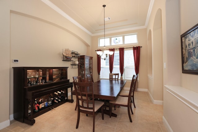 dining space featuring a chandelier, a raised ceiling, arched walkways, light tile patterned flooring, and crown molding