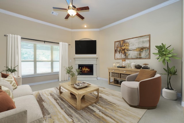 carpeted living area featuring a ceiling fan, baseboards, ornamental molding, and a warm lit fireplace