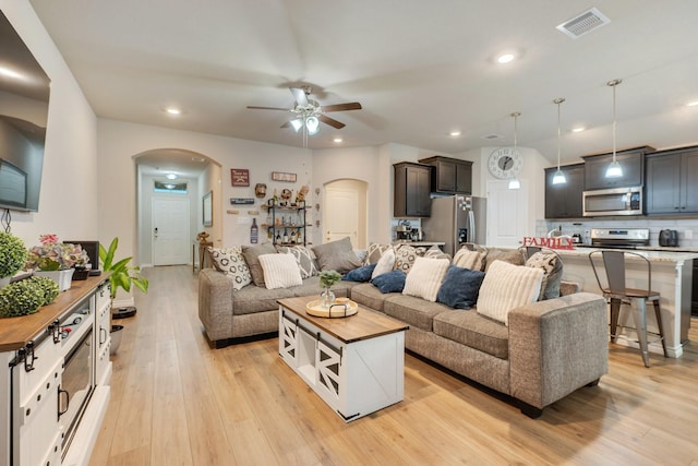 2065 Chief St, Bryan, TX 77807 - living room with arched walkways, ceiling fan, light wood finished floors, and recessed lighting