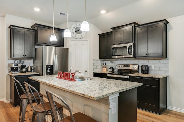 2065 Chief St, Bryan, TX 77807 - kitchen with stainless steel appliances, a sink, tasteful backsplash, light wood-style flooring, and lofted ceiling