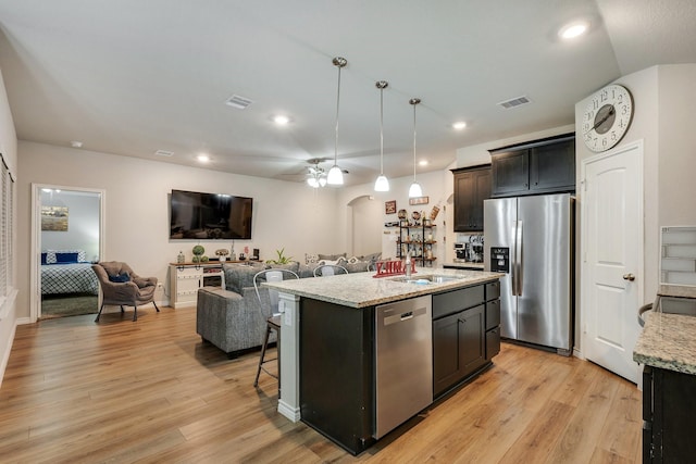 2065 Chief St, Bryan, TX 77807 - kitchen featuring appliances with stainless steel finishes, open floor plan, light wood-style floors, recessed lighting, and ceiling fan