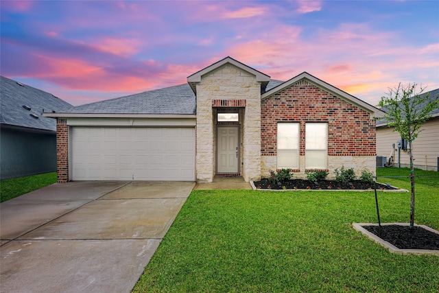 2065 Chief St, Bryan, TX 77807 - ranch-style house featuring a yard, concrete driveway, a garage, stone siding, and brick siding